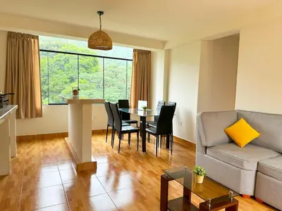 a living room with a couch and a table with chairs at Departamento Maranura Quillabamba in Maranura
