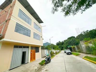 a street with a building and cars parked on the street at Departamento Maranura Quillabamba in Maranura