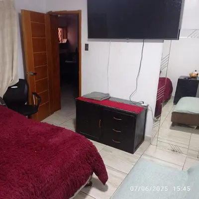 a bedroom with a bed and a tv on the wall at Colibri - Hab Triple in Lima