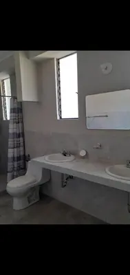 a bathroom with two sinks and a toilet and a mirror at Noah'house in Nazca
