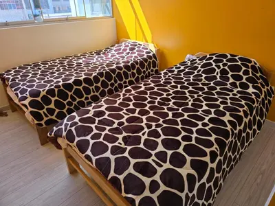 two beds in a room with a black and white comforter at 501 Modern equipped department 3 in Abancay