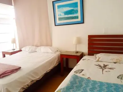 a bedroom with two beds and a picture on the wall at Miraflores Larco in Lima