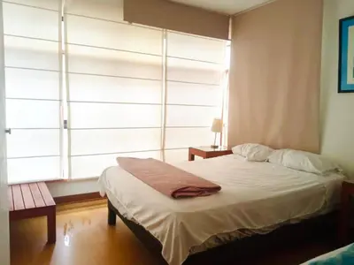 a bedroom with a white bed with a window at Miraflores Larco in Lima