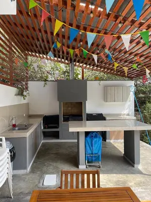 a patio with a table and flags hanging from a ceiling at Refugio en Cieneguilla relax, piscina y sol in Cieneguilla