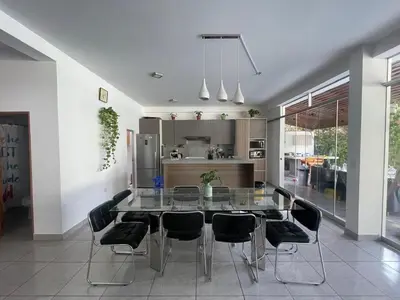 a dining room with a glass table and black chairs at Refugio en Cieneguilla relax, piscina y sol in Cieneguilla