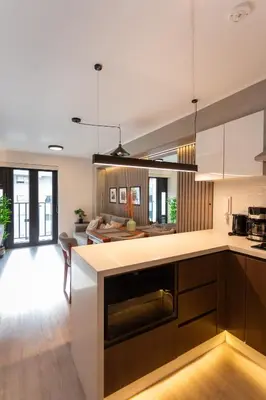 a kitchen with a counter and a living room at Brand-new designer apt - Pool in Miraflores in Lima