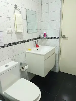 a white bathroom with a toilet and a sink at Katty's apartment - Las Malvas in Lima