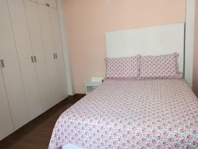 a bedroom with a bed and a white cabinet at Katty's apartment - Las Malvas in Lima