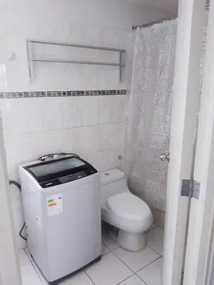 a white bathroom with a toilet and a shower at Miraflores, Lima, habitación independiente in San Antonio