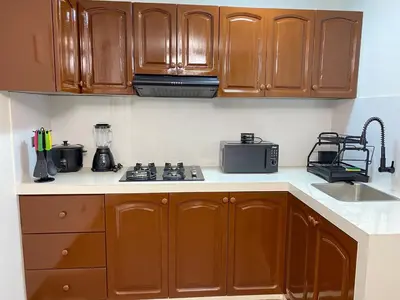 a kitchen with wooden cabinets and a blender on the counter at El Encanto Espacio Calido A warm space in Los Olivos in Lima