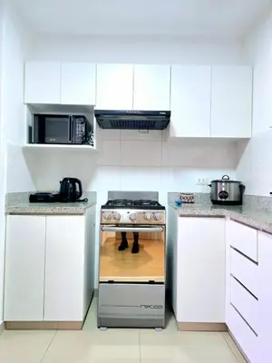 a kitchen with white cabinets and a stove at Suite Ocean View con WiFi San Miguel 1502 in Lima