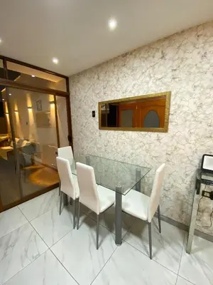 a dining room with a glass table and white chairs at Brisa Dorada - Luxury Apartment in Los Olivos in Lima