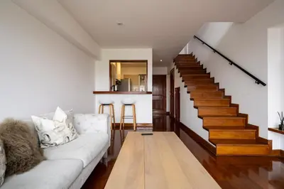 a living room with a couch and stairs at Luxury Duplex Stunning Golf Views - Prime Location in Lima