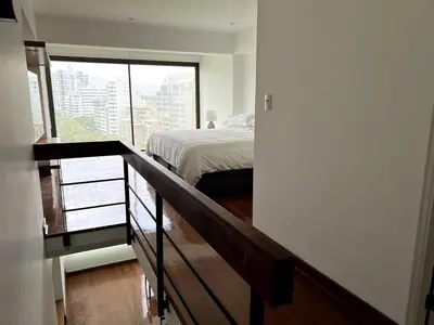 a bedroom with a bed and a large window at Luxury Duplex Stunning Golf Views - Prime Location in Lima
