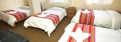 a hotel room with three beds with bows on them at Andean Dreams 1 in Cusco