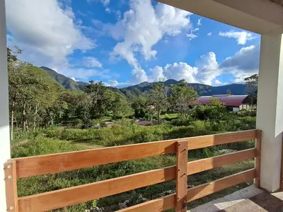 a view from a porch with a fence and mountains at Bellavista Hospedaje in Oxapampa