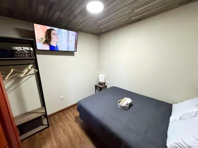a bedroom with a bed and a tv on the wall at Casa Cusco in Cusco
