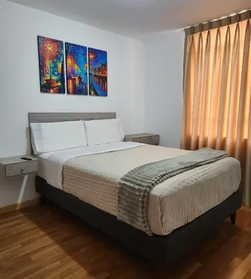 a bedroom with a bed with two paintings on the wall at Casa Victoria in Lima