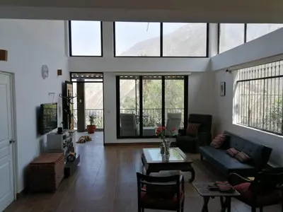 a living room with a couch and a table at Nice country house with pool and beautiful view in Huarochirí