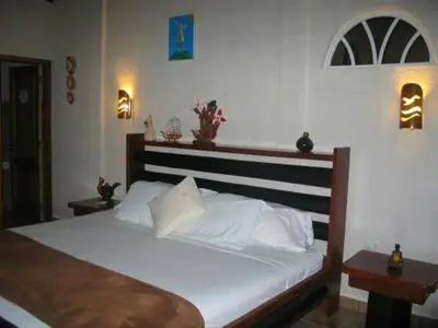 a bedroom with a large bed with white sheets at Magnum House in Huancayo