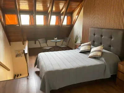 a bedroom with a large bed and a table at SAELUMA Suite Apart in Lima