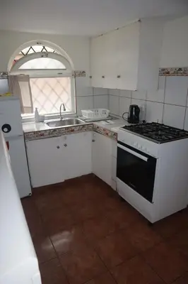 a white kitchen with a stove and a sink at Casita de Miraflores calle Ocharan a 5 minutos de Larcomar in Lima