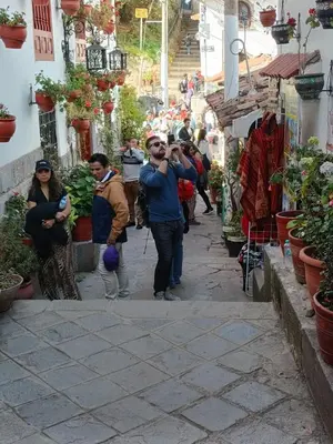 a man taking a picture of a group of people walking down a street at 7 Borreguitos GUESTHOUSE in Cusco