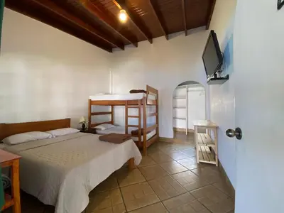 a bedroom with two bunk beds and a tv at QPÑ Hoteles - Hacienda Nieve Nieve in Balconcillo de Aviyay