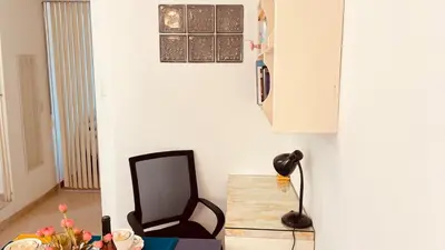 a room with a chair and a table and a lamp at Cómodo e independiente minidepartamento a pasos del Circuito Mágico in Lima