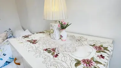 a table with a lamp and a vase of flowers on it at Cómodo e independiente minidepartamento a pasos del Circuito Mágico in Lima