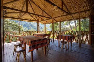 a room with tables and chairs and a view of the mountains at Viamonte EcoLodge in Santa Teresa