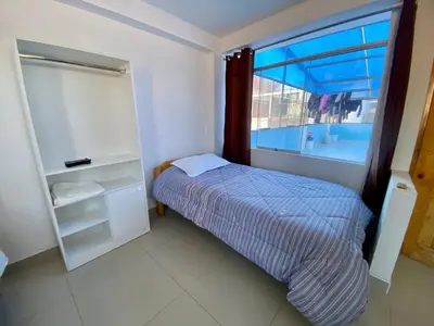 a small bedroom with a bed and a window at Marlen's Qorywasi in Cusco