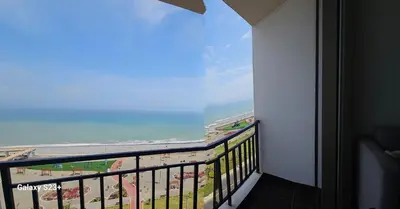 a balcony with a view of the beach and the ocean at An apartment with an ocean view, near the airport in Lima