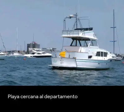 a white boat in the water with other boats at An apartment with an ocean view, near the airport in Lima
