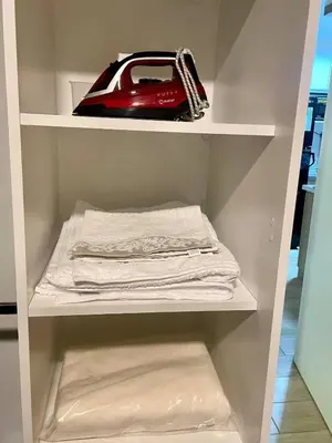 a white closet with a red purse and towels at Céntrico departamento in Lima