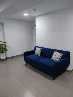 a blue couch sitting in a room at Céntrico departamento in Lima