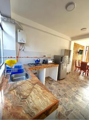 a kitchen with a counter with a sink and a refrigerator at Lofts Illawasi in Urubamba