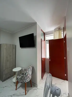 a living room with a tv and a table and chairs at Nayarak Paracas in Paracas