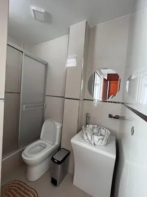 a white bathroom with a toilet and a sink at Nayarak Paracas in Paracas