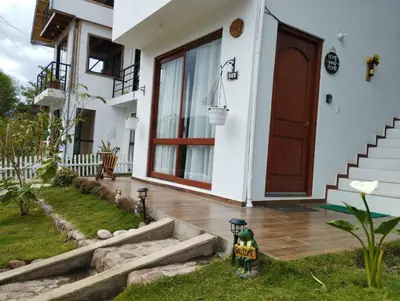 a house with a wooden door and a porch at Sweet Home Oxapampa in Oxapampa