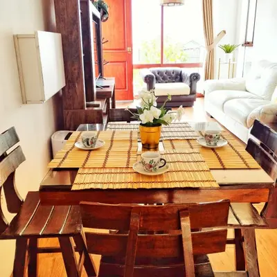 a living room with a wooden table with flowers on it at Sweet Home Oxapampa in Oxapampa
