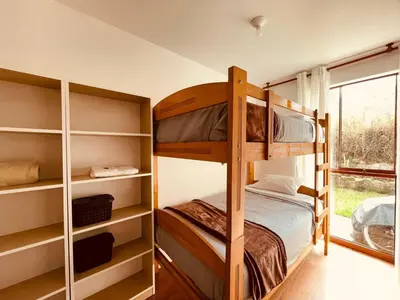 a bedroom with bunk beds and a window at Sweet Home Oxapampa in Oxapampa