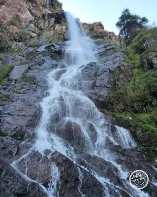 a waterfall on the side of a mountain at Hanaq Pacha Wasi in Calca
