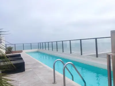 a swimming pool with a view of the ocean at Departamento Costa Verde San M in Lima