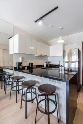 a kitchen with a counter with bar stools at Sunline 2BR by Geko in Lima
