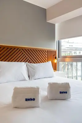 a white bed with two towels on top of it at Sunline 2BR by Geko in Lima