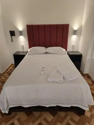 a bedroom with a large bed with two towels on it at Hostal Prestigio in Lima