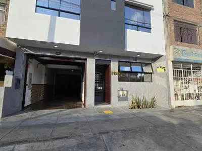 a large building with a hallway leading to a garage at Hostal Prestigio in Lima