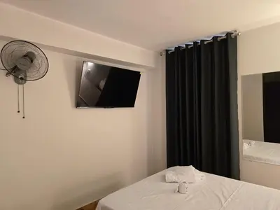 a hotel room with a bed and a fan at Hostal Prestigio in Lima
