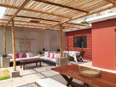a wooden pergola with couches and tables on a patio at Villa Lunahuana in Lunahuaná